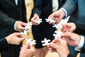 Teamwork - Business people solving a puzzle