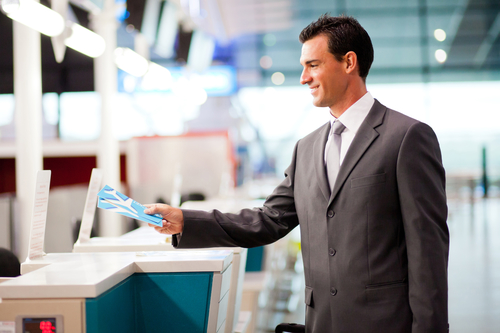 handsome businessman handing over air ticket at airline check in counter